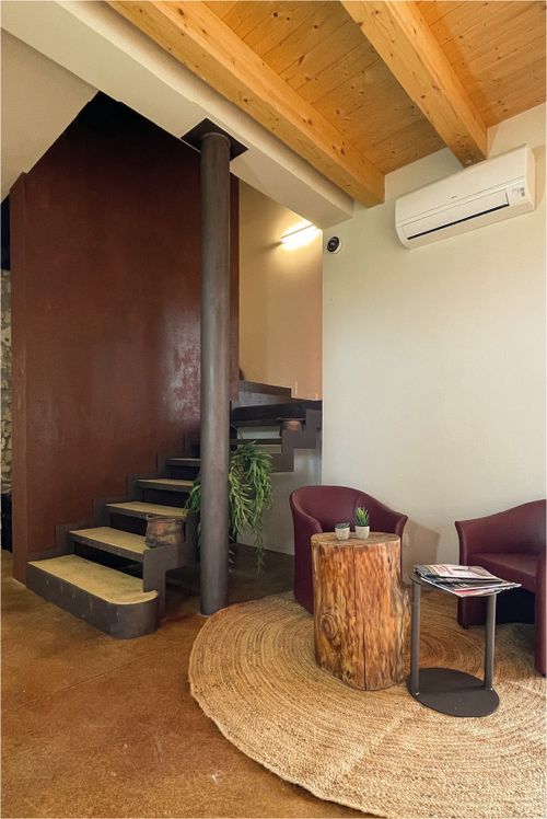 Zona relax interna con poltrone e scala di design